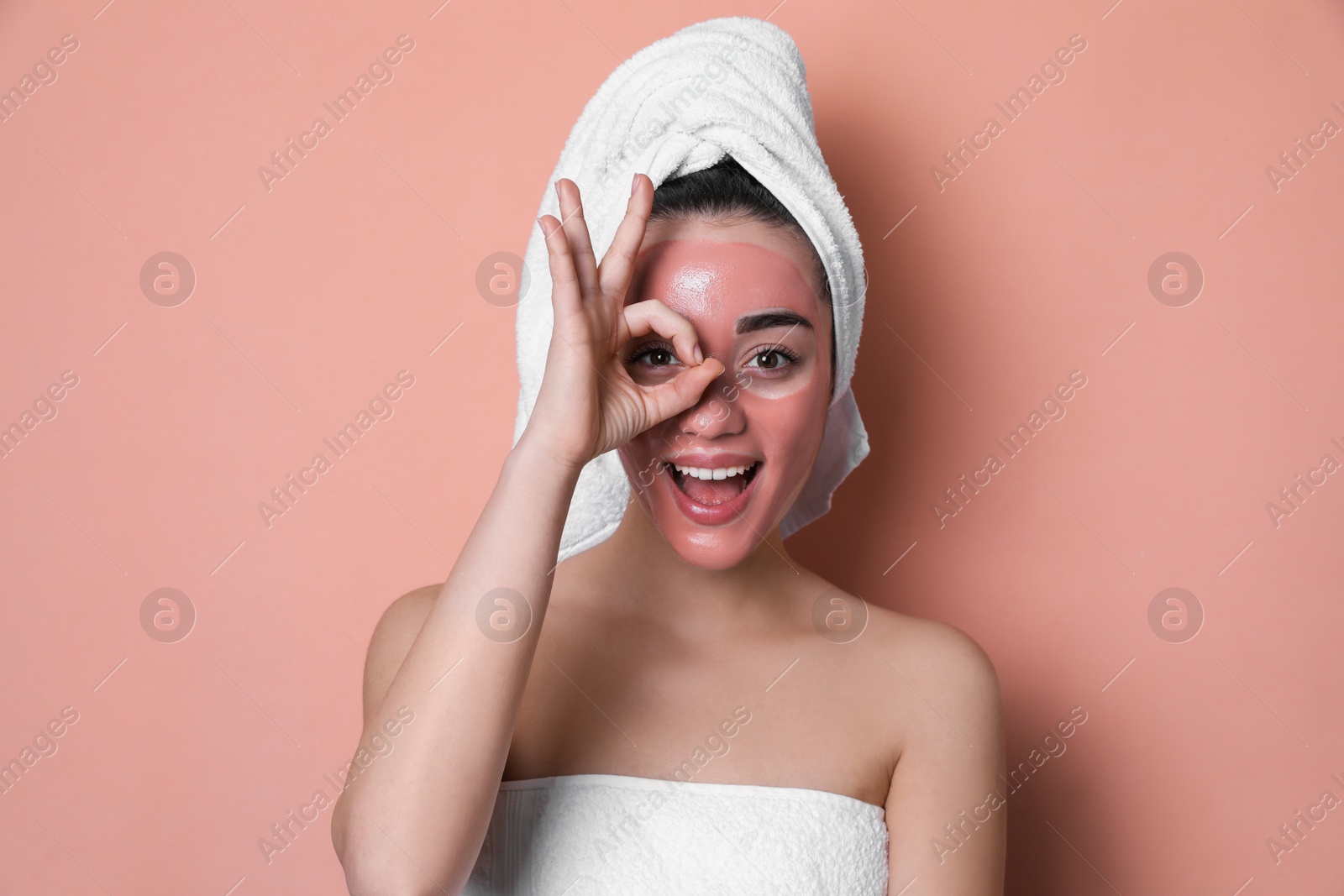 Photo of Woman with pomegranate face mask showing Ok on pale coral background