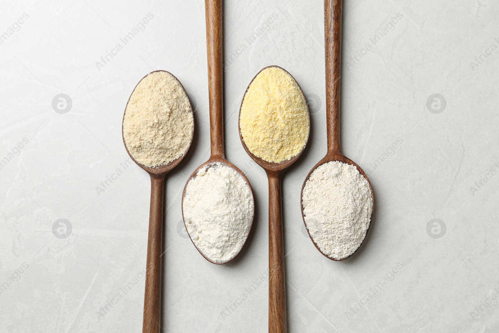 Photo of Spoons with different types of flour on table, top view