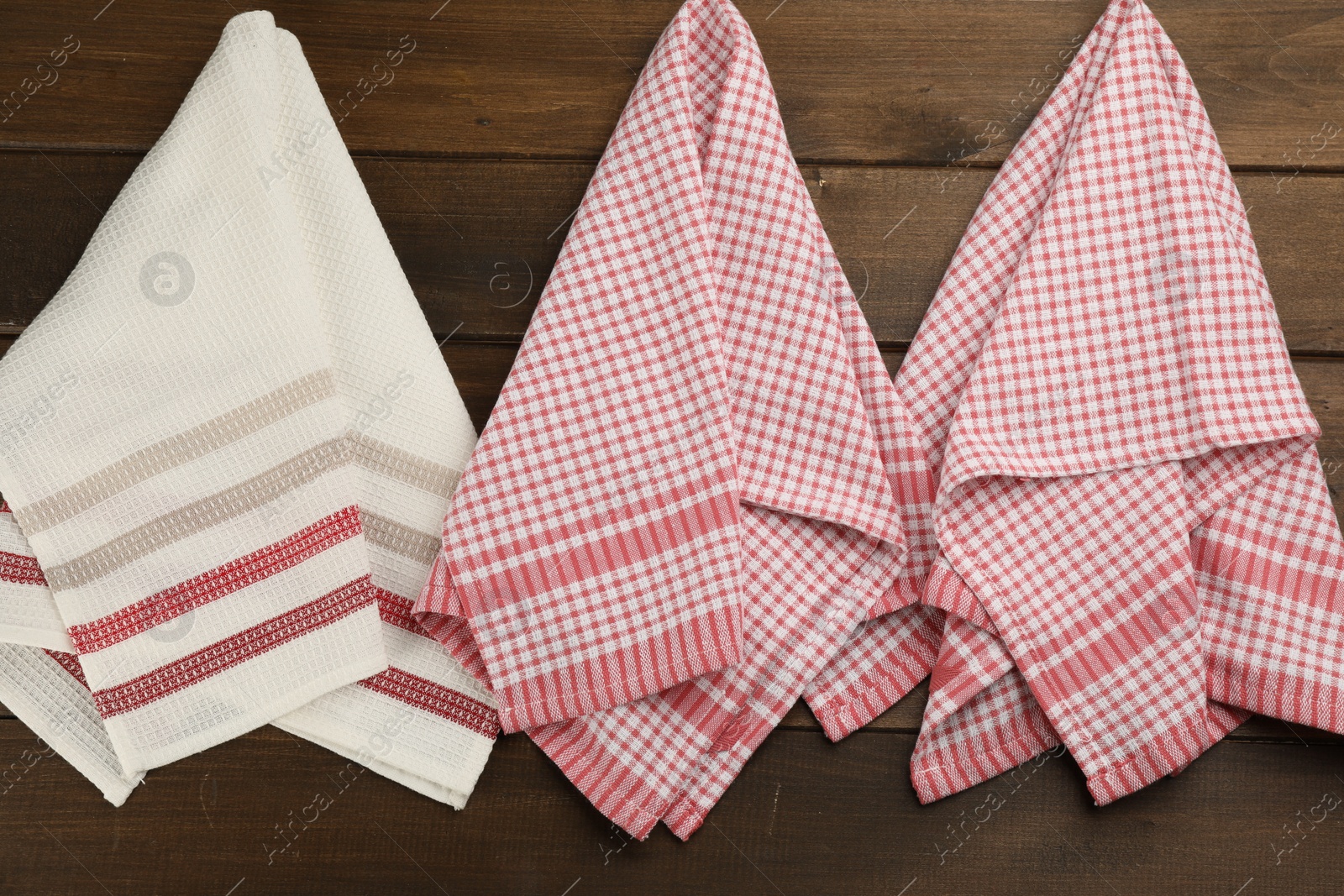 Photo of Different kitchen towels hanging on wooden wall