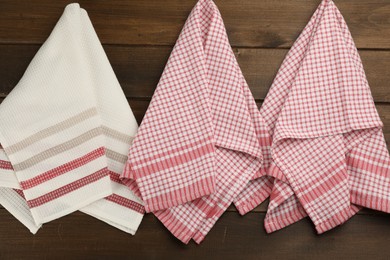 Photo of Different kitchen towels hanging on wooden wall