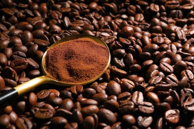 Photo of Spoon with ground coffee on roasted beans, closeup. Space for text