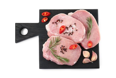 Photo of Black wooden board with pieces of raw pork meat and spices isolated on white, top view