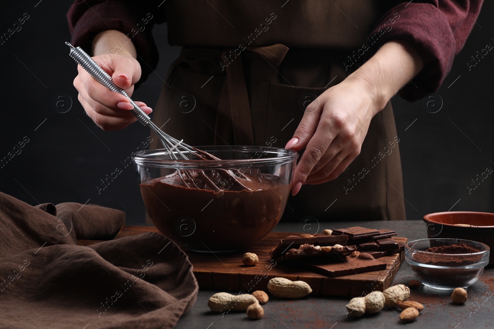 Photo of Woman with whisk mixing delicious chocolate cream at table, closeup