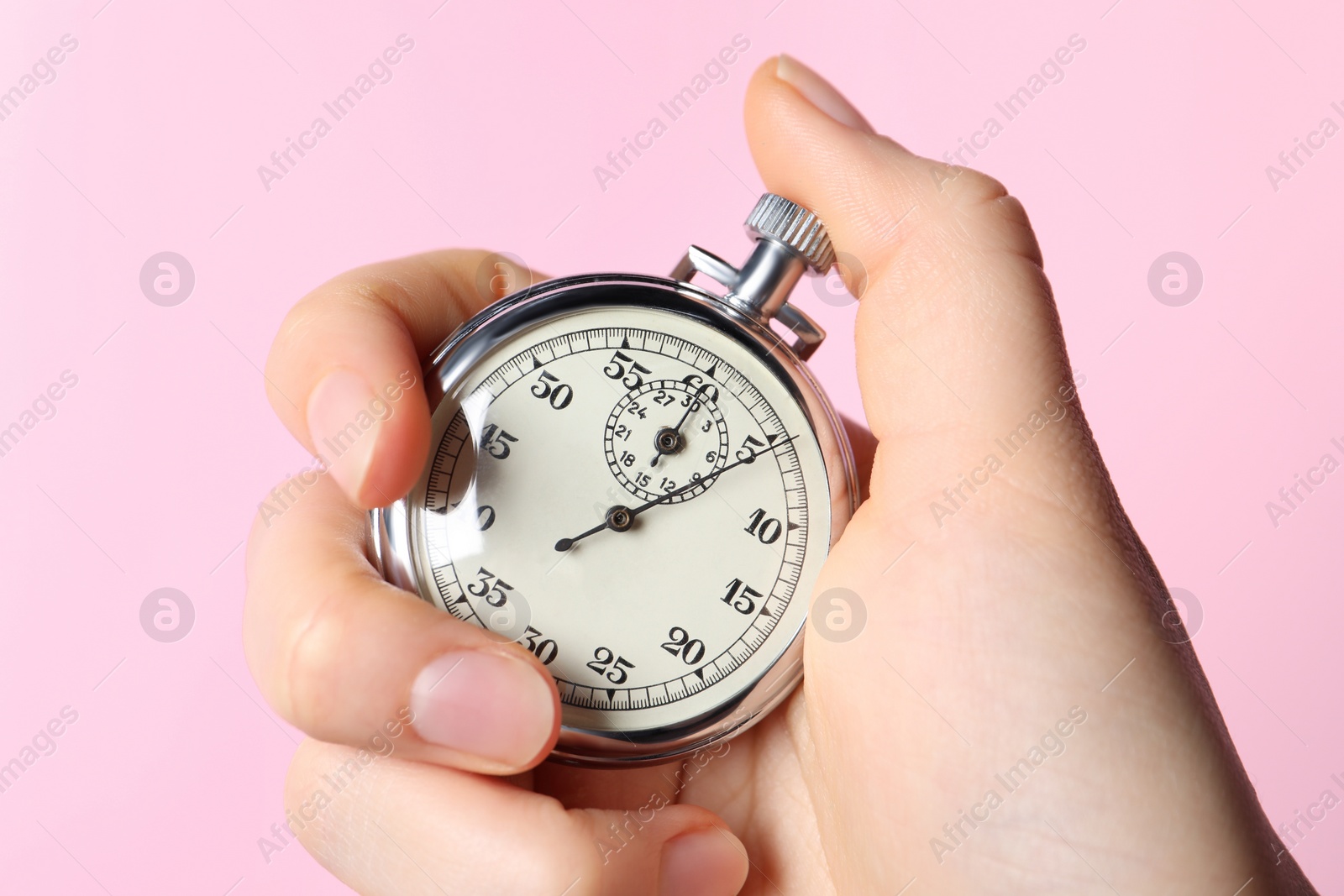 Photo of Woman holding vintage timer on pink background, closeup