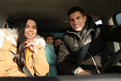 Photo of Happy family with little children inside modern car