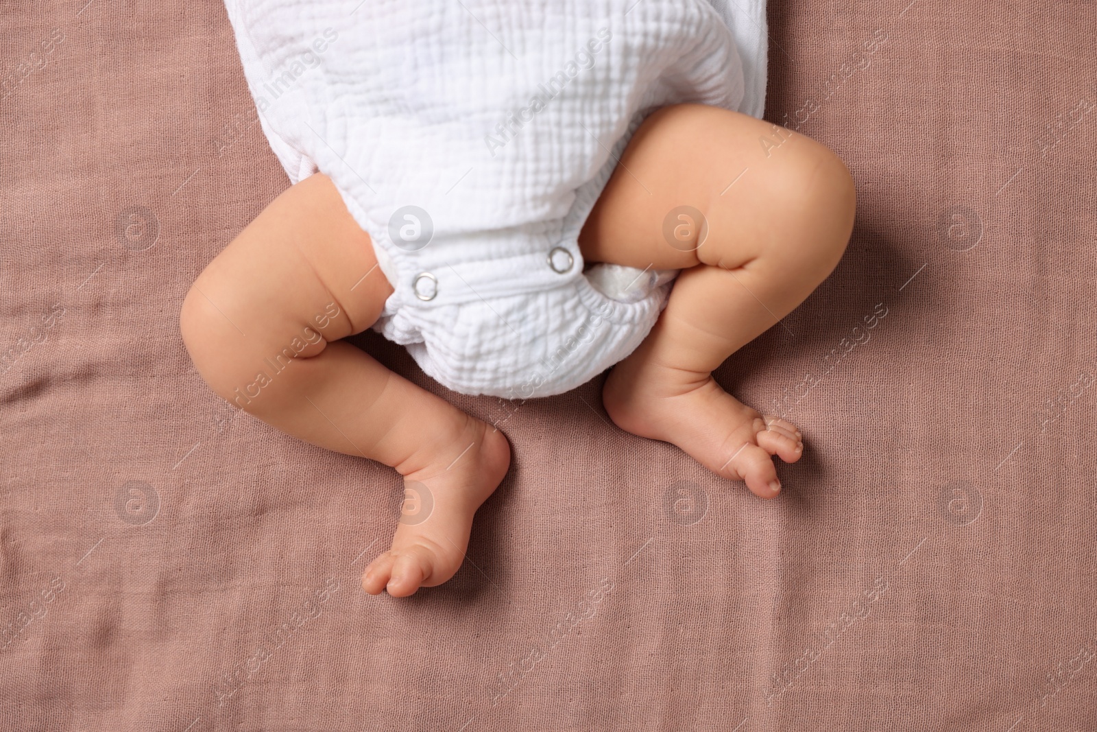 Photo of Newborn baby lying on blanket, top view
