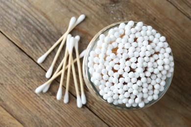 Many cotton buds on wooden table, flat lay