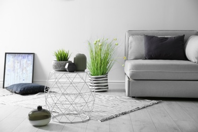 Photo of Beautiful living room interior with vases and houseplant on table