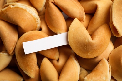 Photo of Paper with prediction on pile of fortune cookies, closeup