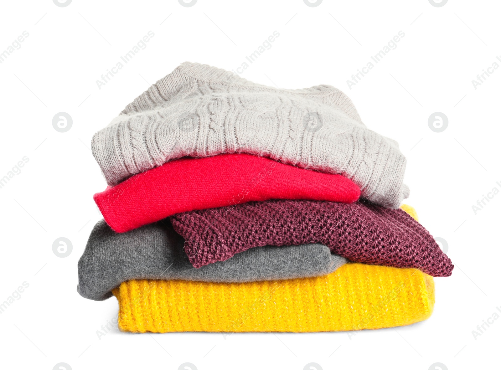 Photo of Stack of warm knitted clothes on white background