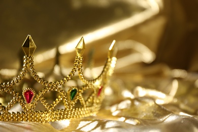 Photo of Beautiful ancient crown on golden fabric, space for text. Fantasy item