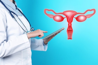 Doctor with tablet and illustration of female reproductive system on light blue background, closeup. Gynecological care 