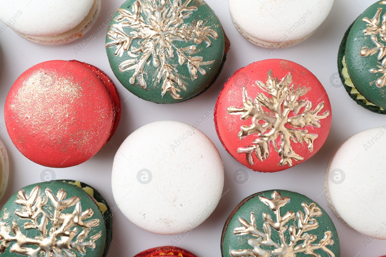 Photo of Beautifully decorated Christmas macarons on white background, top view