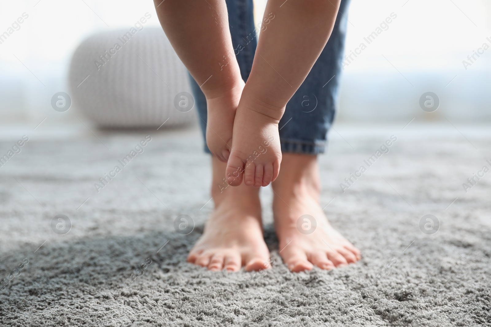 Photo of Baby doing first steps with mother's help, closeup