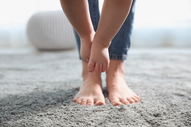 Baby doing first steps with mother's help, closeup