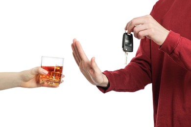 Man with car keys refusing alcohol on white background, closeup. Don't drink and drive concept