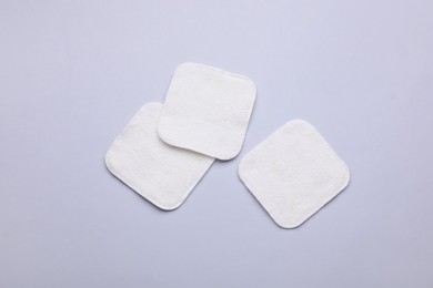 Clean cotton pads on light grey background, flat lay
