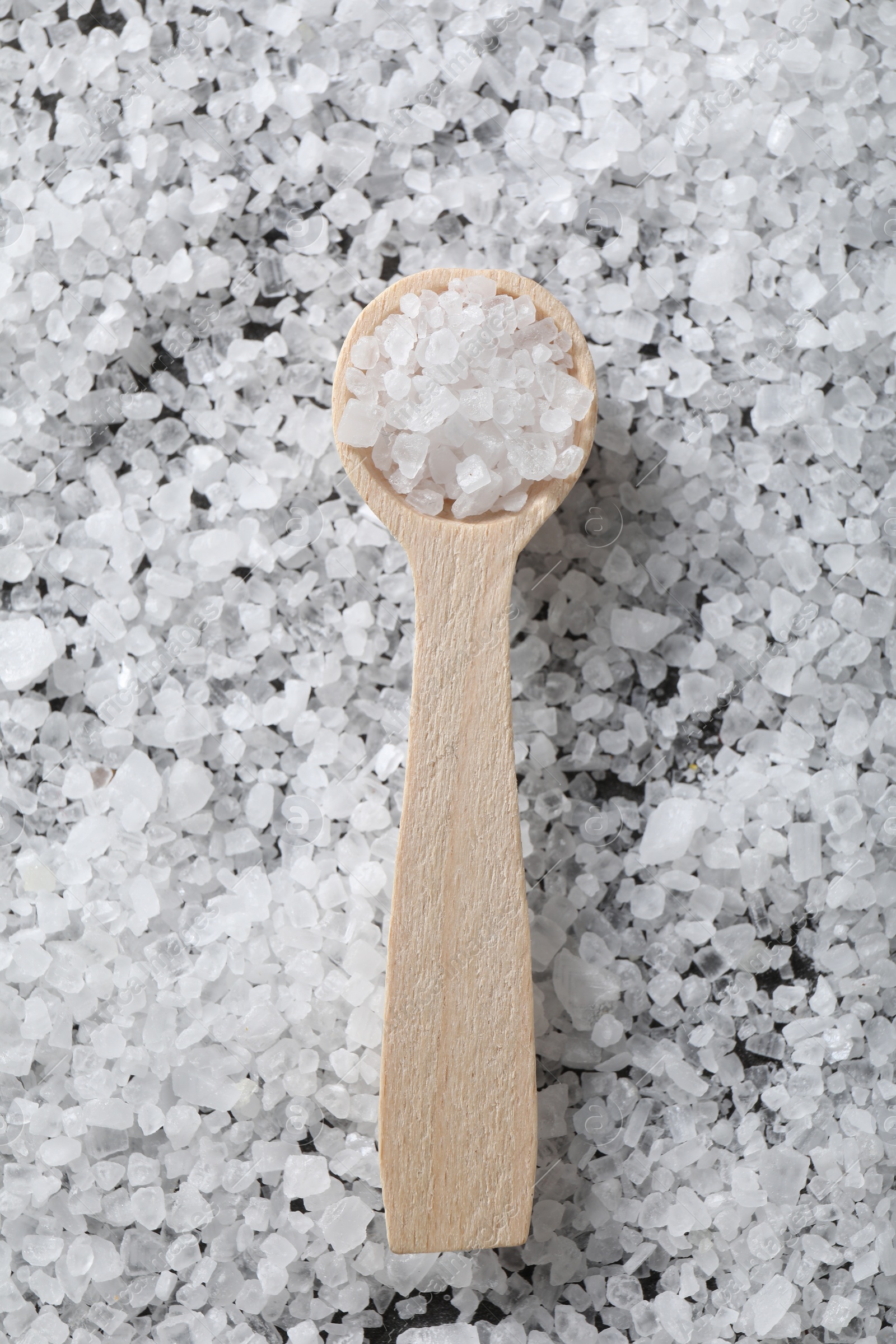 Photo of Natural salt and wooden spoon, top view