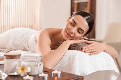 Photo of Young woman resting on massage couch in spa salon