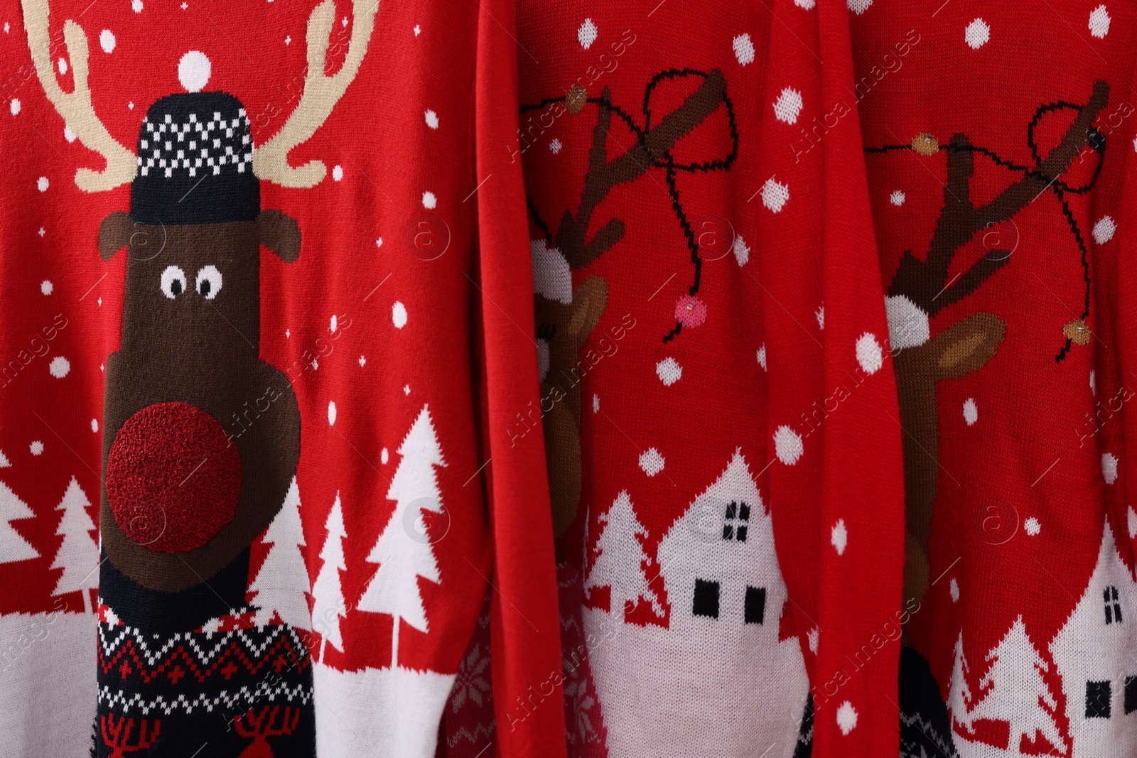 Photo of Many different Christmas sweaters as background, closeup view