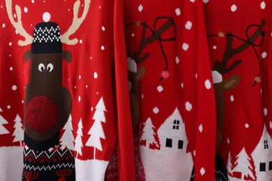 Many different Christmas sweaters as background, closeup view
