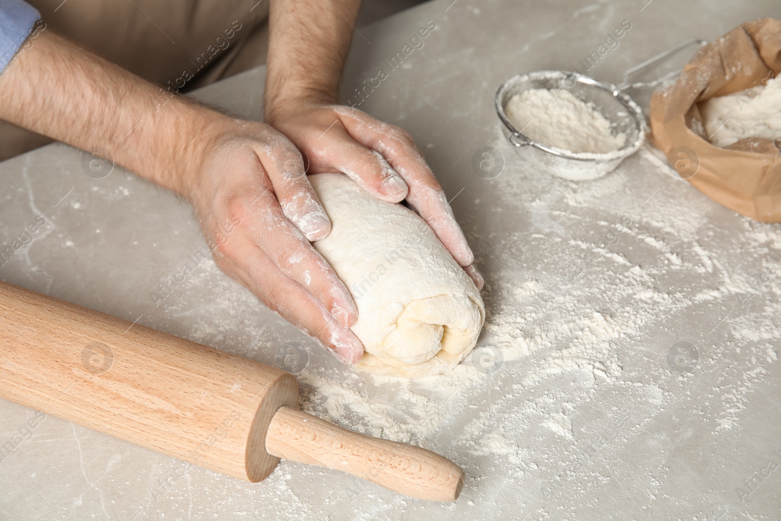 Photo of Man kneading dough for pastry on table