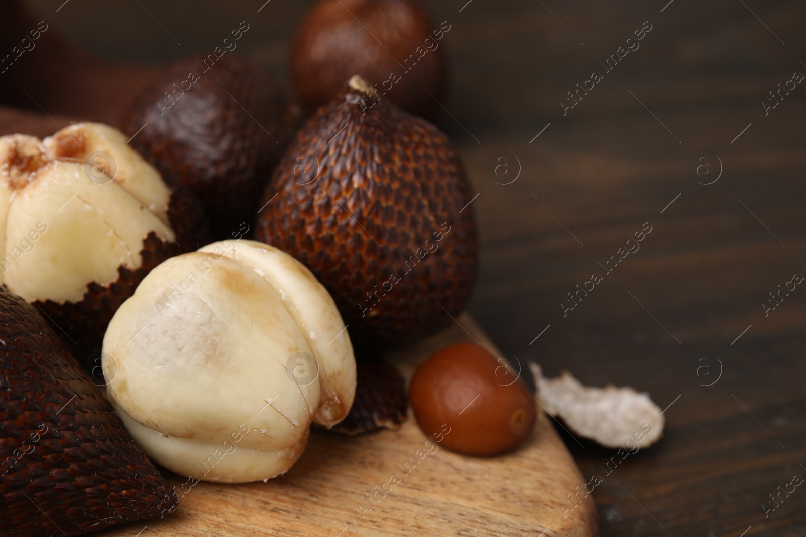 Photo of Fresh salak fruits on wooden table, closeup. Space for text