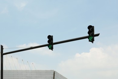Photo of Traffic lights against blue sky outdoors. Road rules
