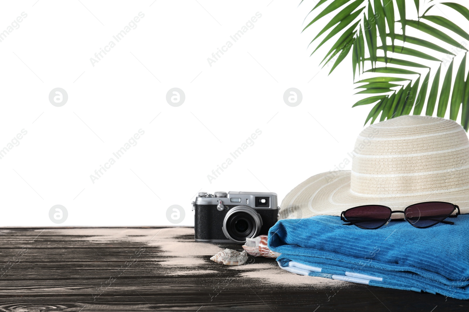 Photo of Different beach objects on black wooden table against white background. Space for text