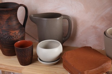 Photo of Clay dishes on wooden table in workshop