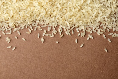 Parboiled rice on color background, top view with space for text