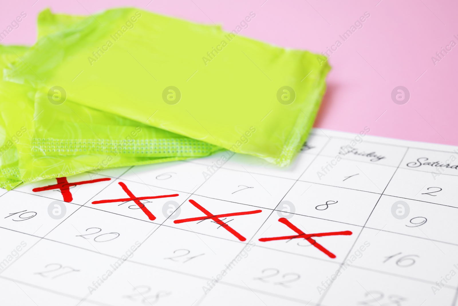 Photo of Calendar and menstrual pads on color background, closeup with space for text. Gynecological care