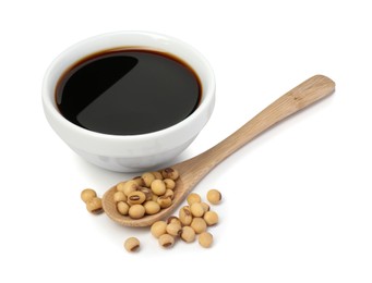 Tasty soy sauce in bowl, soybeans and spoon isolated on white