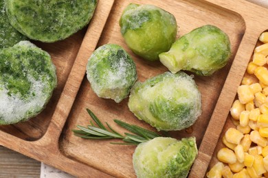 Tray with different frozen vegetables on wooden table, top view