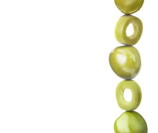 Cut and whole green olives on white background