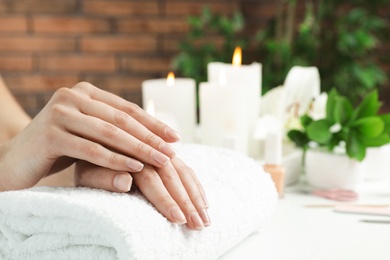 Photo of Woman showing smooth hands on towel at table, closeup with space for text. Spa treatment