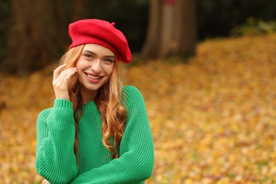 Photo of Portrait of smiling woman wearing autumn sweater outdoors. Space for text