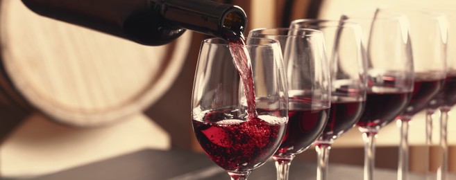 Image of Pouring wine from bottle into glass. Banner design