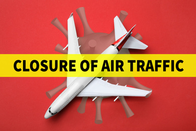 Image of Closure of air traffic through quarantine during coronavirus outbreak. Airplane on red background, top view