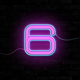 Image of Glowing neon number 6 sign on brick wall