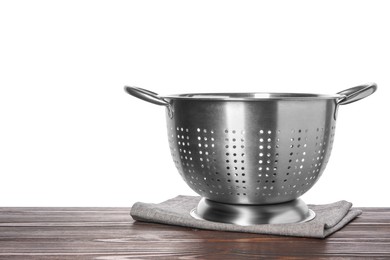 Photo of Metal colander and napkin on wooden table against white background. Space for text