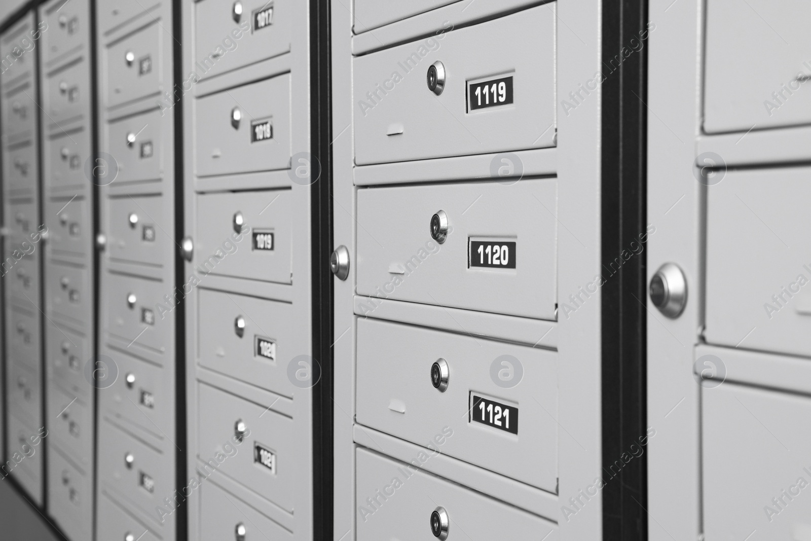 Photo of Closed metal mailboxes with keyholes and sequence numbers indoors