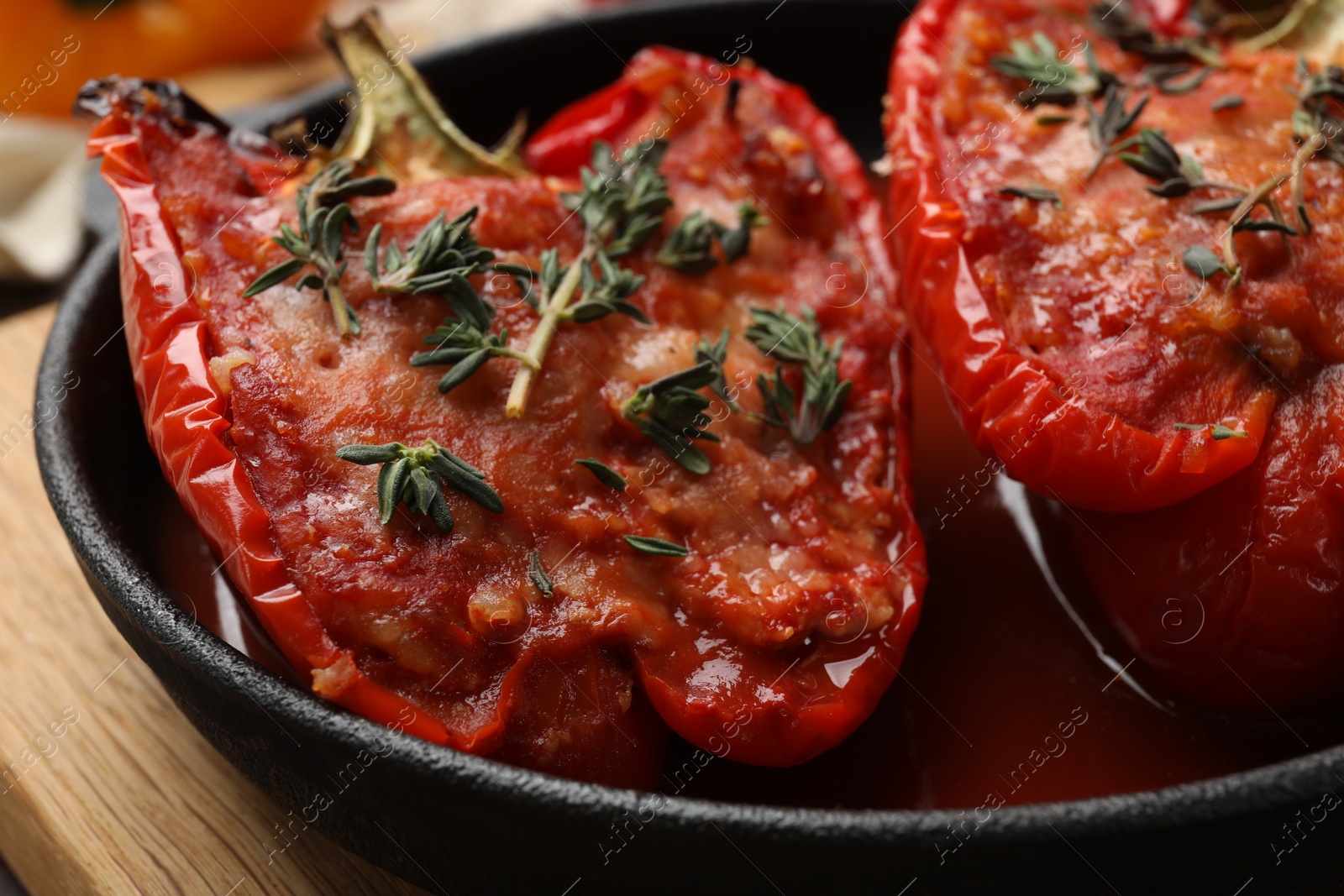 Photo of Tasty stuffed peppers in dish on table, closeup