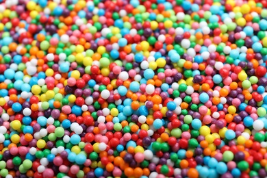 Photo of Bright colorful sprinkles as background, closeup. Confectionery decor