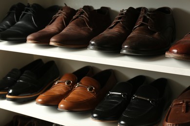Photo of White shelving unit with different leather shoes