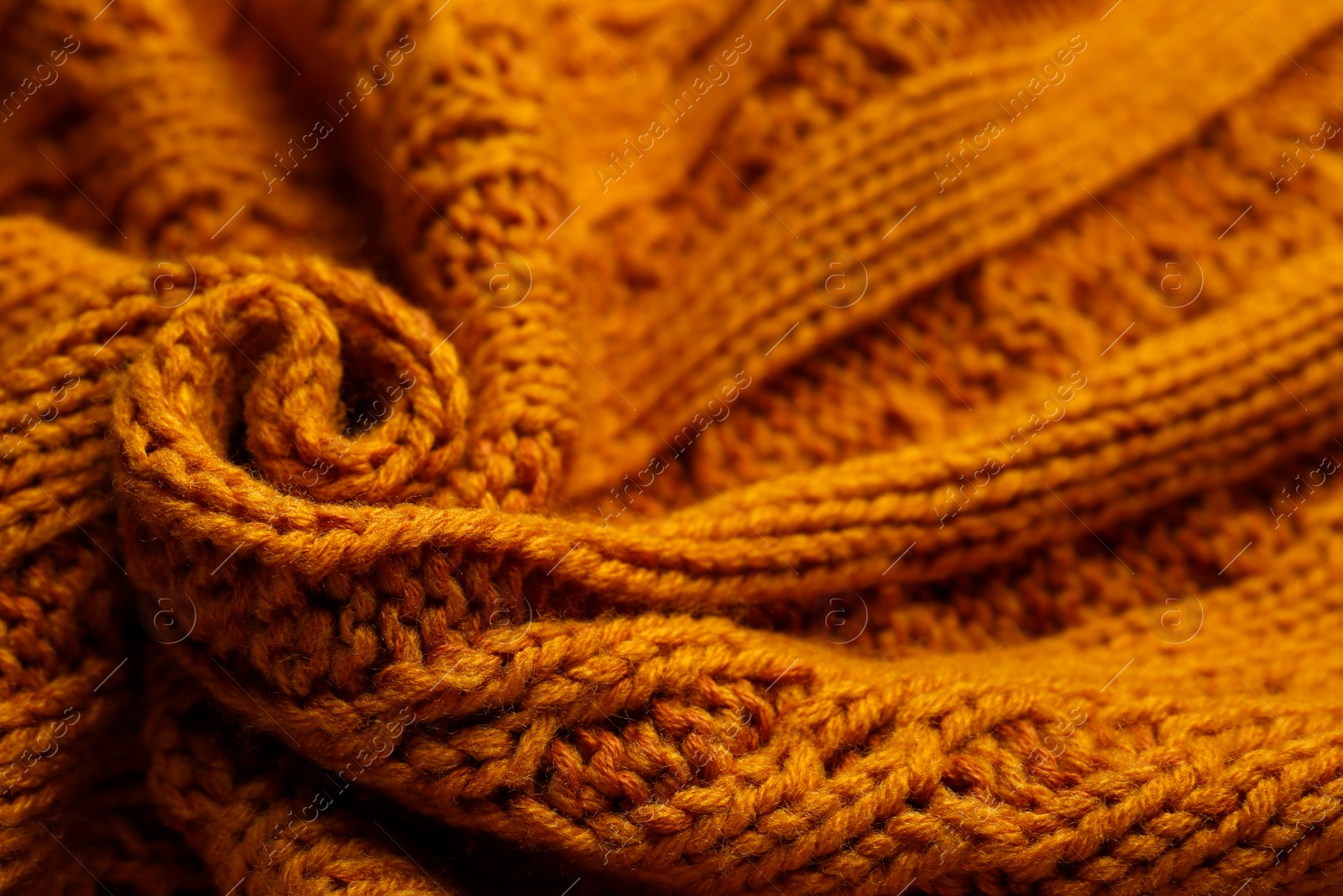 Photo of Beautiful orange knitted fabric as background, closeup