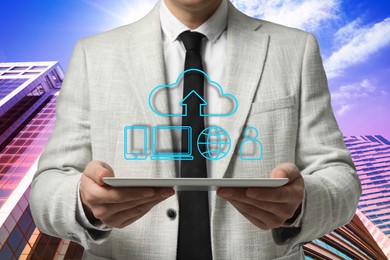 Web hosting. Man holding tablet against buildings, closeup. Digital cloud with arrow and icons over gadget