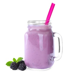 Photo of Tasty fresh milk shake in mason jar and blackberries on white background