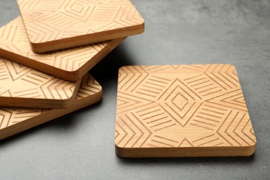 Photo of Stylish wooden cup coasters on grey table