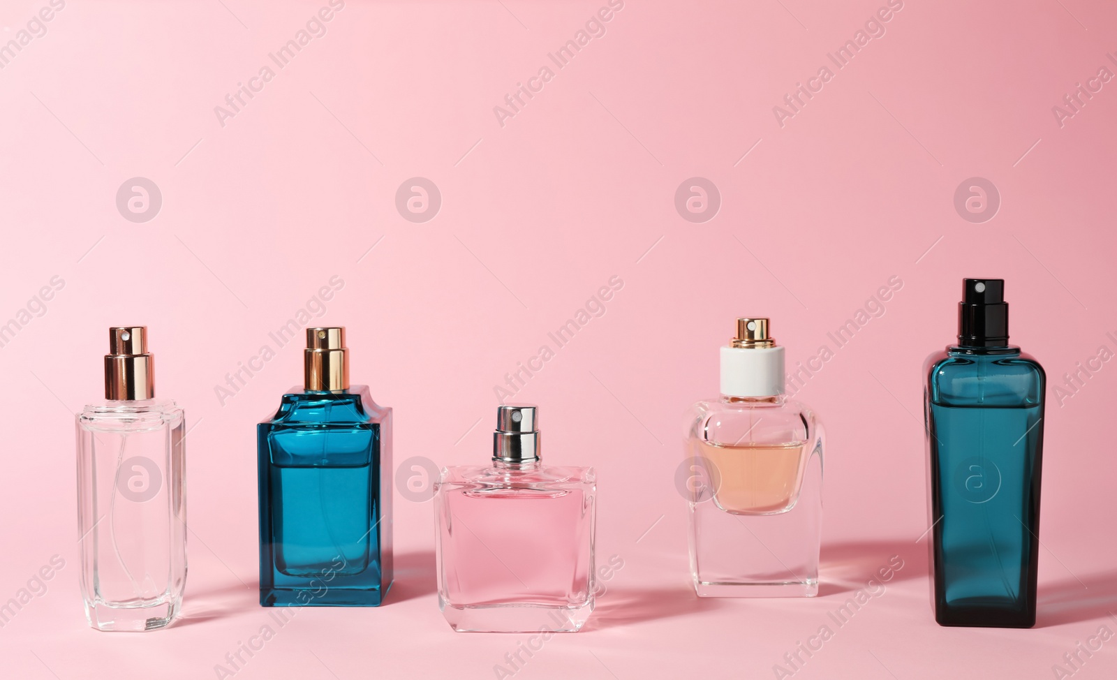 Photo of Bottles of perfume on color background